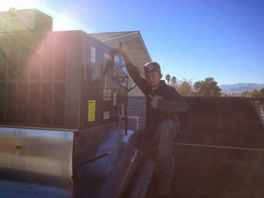 HVAC technician performing HVAC Inspection on a rooftop unit in Tracyton